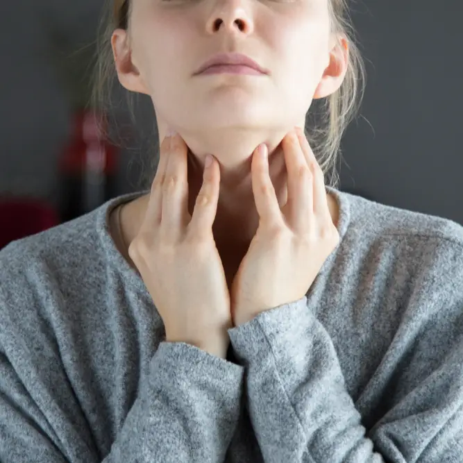 Pharmacy First Sore Throat - Woman holding her throat